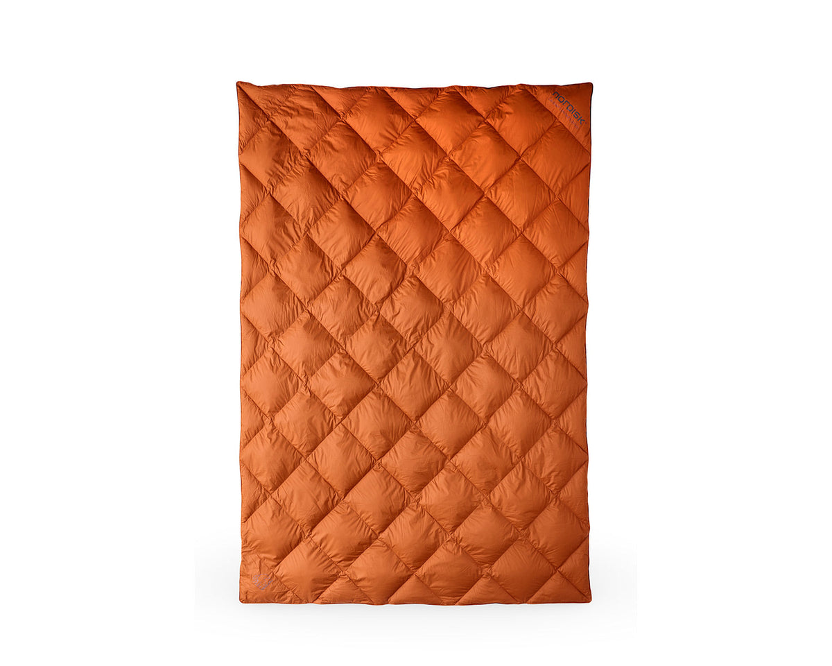 Orange quilted blanket on a white background