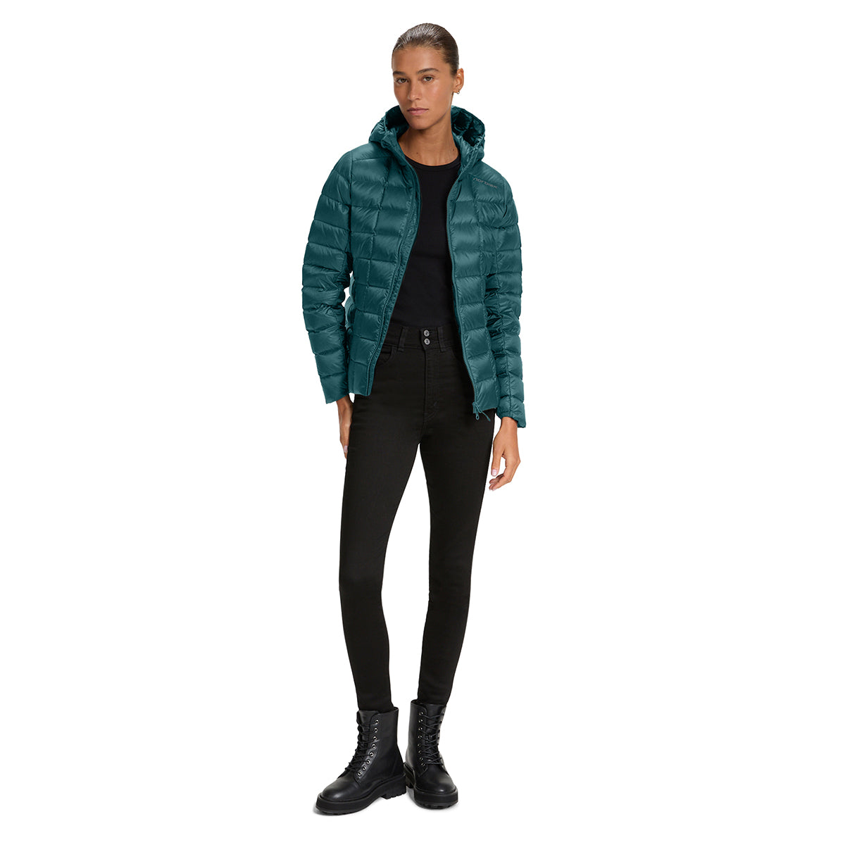 A model wearing a teal green hooded puffer jacket over a black top and black skinny pants, paired with black lace-up boots, on a solid white background.