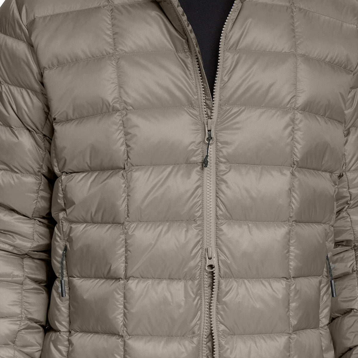 A close-up of a quilted puffer jacket in a muted taupe-gray color, featuring horizontal stitching and a central zipper.