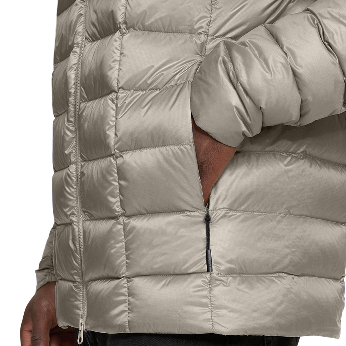 Close-up of a person wearing a shiny quilted puffer jacket in a light taupe-beige color, showing the texture, zippered pocket, and sleeve detail.