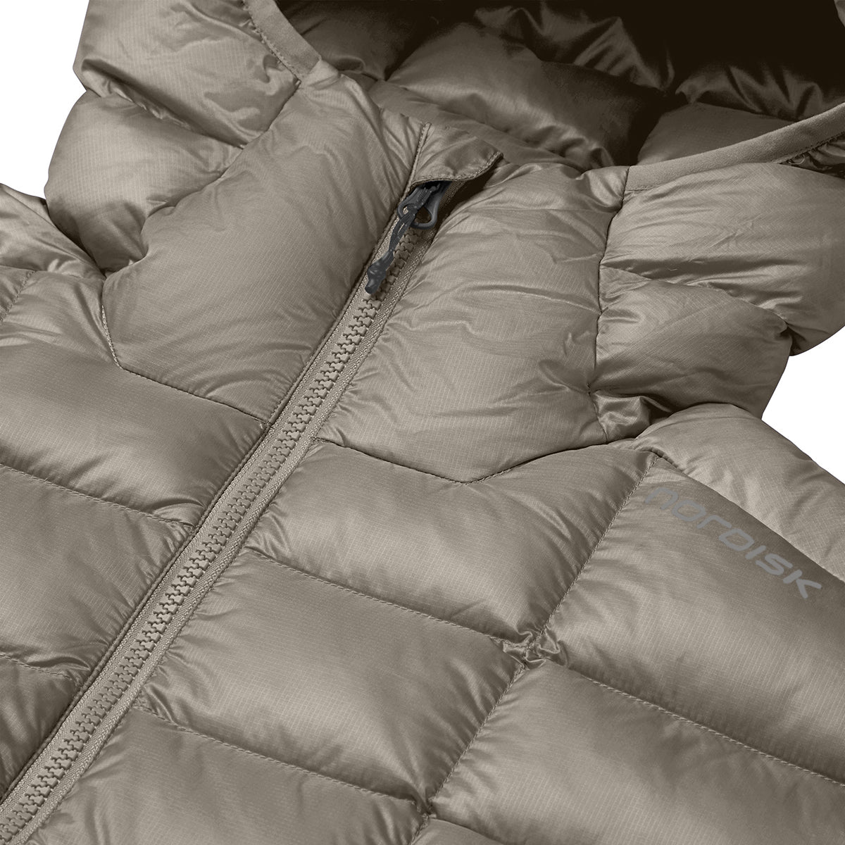 Close-up of a padded winter jacket in a warm taupe-beige color, showing the quilted texture, zipper, and a partial view of the hood. The brand name 'NORDISK' is visible on the sleeve.