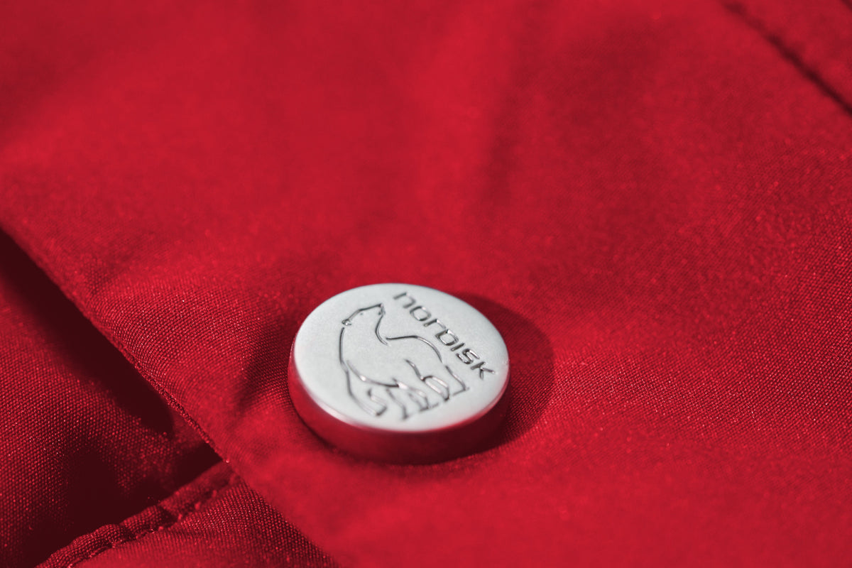 Close-up of a button with a logo on a red fabric background