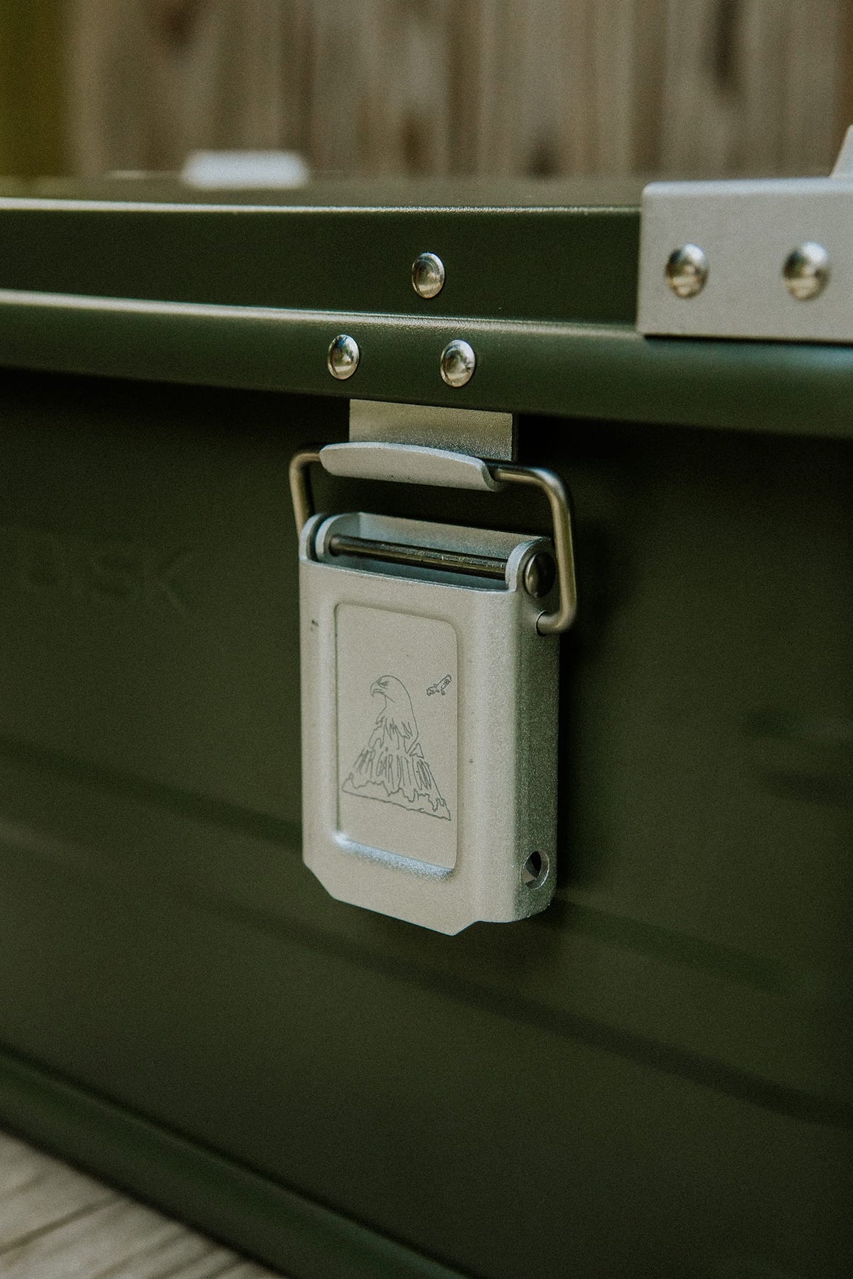 Grøn aluminiumsboks med ørn-logo, lukket og klar til brug