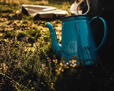 Madam Blå kande, blå campingkande med Nordisk logo i grøn natur