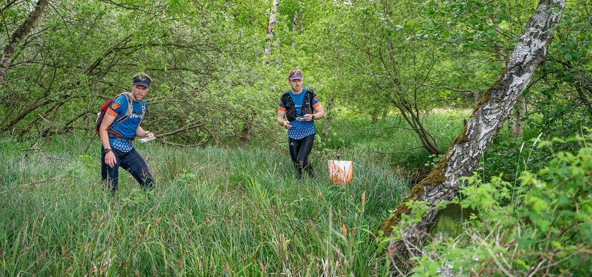 To atleter orienterer sig i grønt terræn under Adventure Run Silkeborg