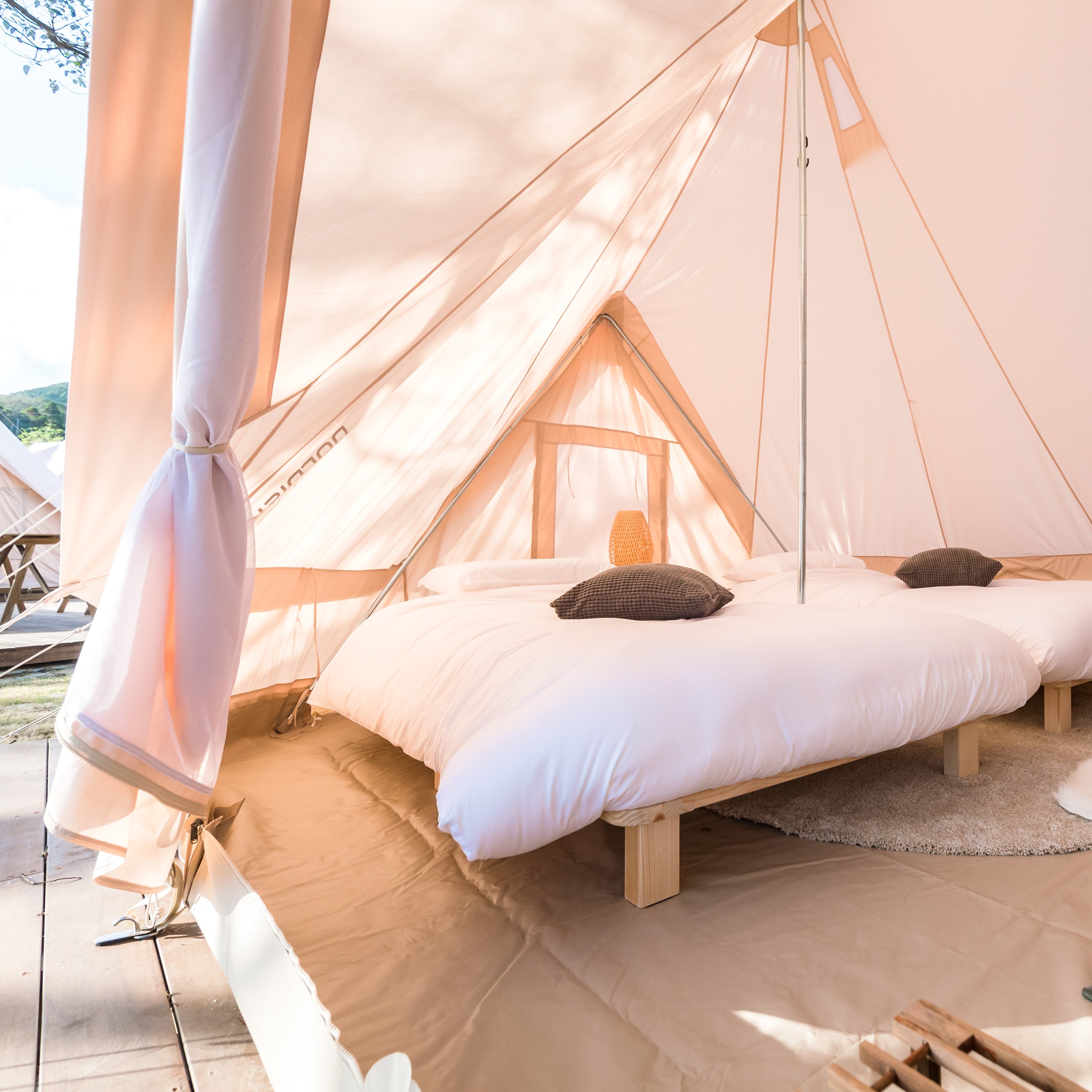 Luksus teltinteriør i Nordisk Village med senge og puder.